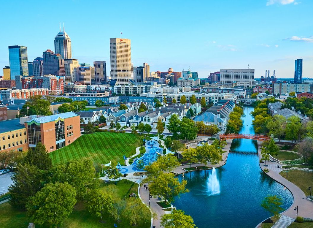Aerial view of urban park and Indianapolis, IN skyline.