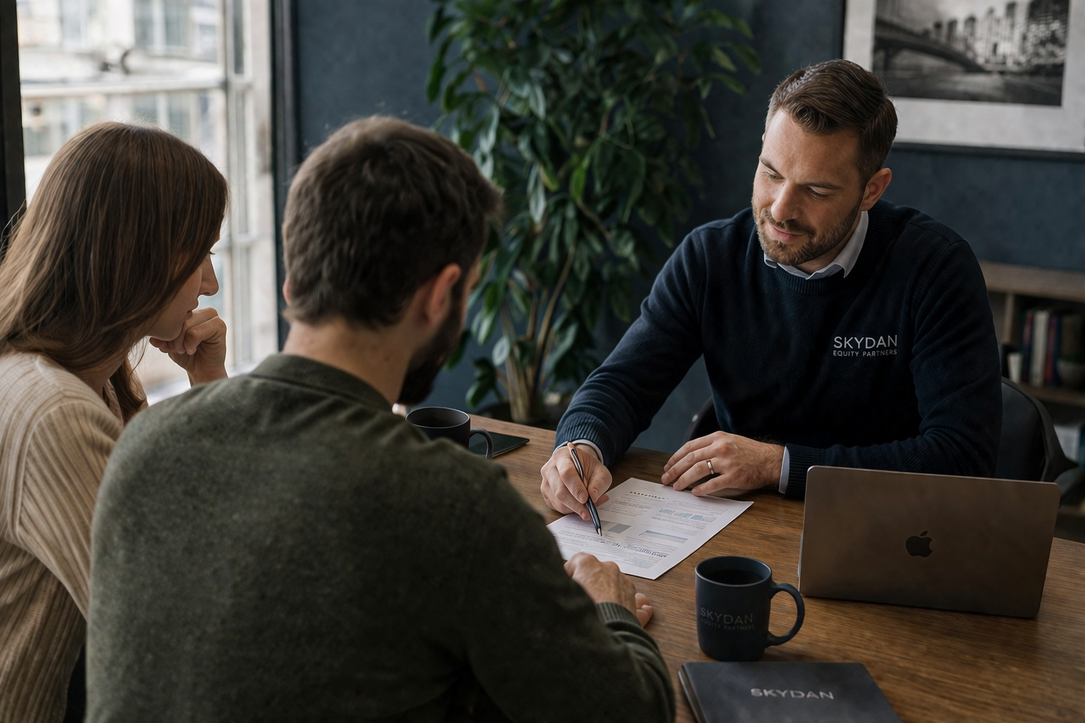 Skydan professional sitting down with a young couple as they review their options. office discussion in natural light